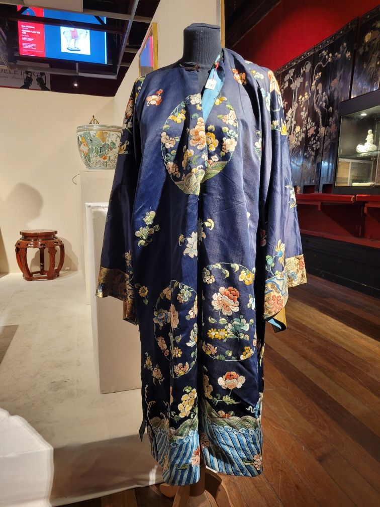 Null 中国。午夜蓝色丝绸女装，多色刺绣花卉和花纹装饰。镀金的袖子。
19世纪晚期
高度：111厘米。轻微磨损。黑色珐琅银扣。