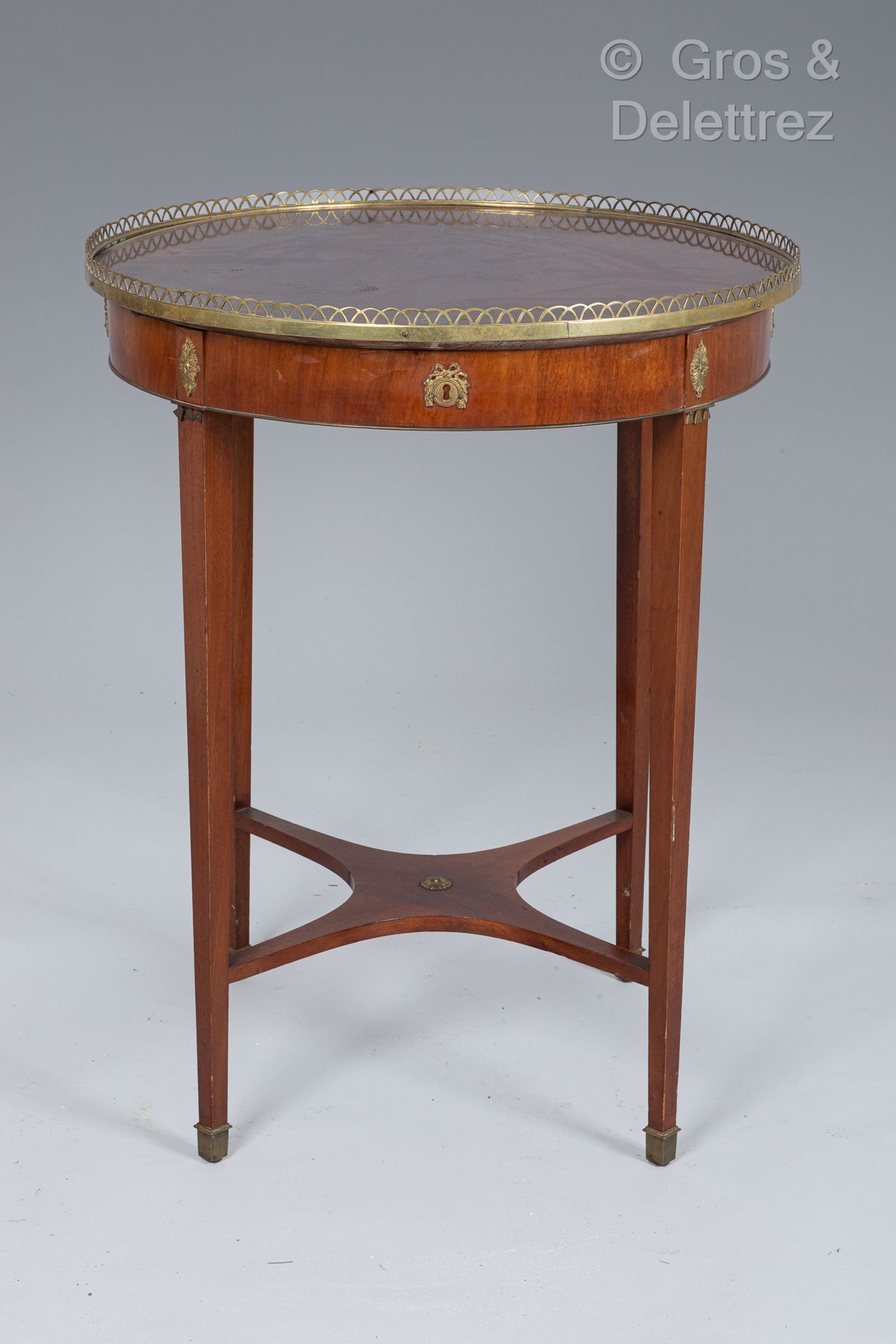 Null 异国情调的木皮圆形基座桌，腰部有一个抽屉。它站在四个由支架连接的鞘状腿上。
镂空的铜质画廊。
18世纪末的瑞典作品
75 x 59厘米