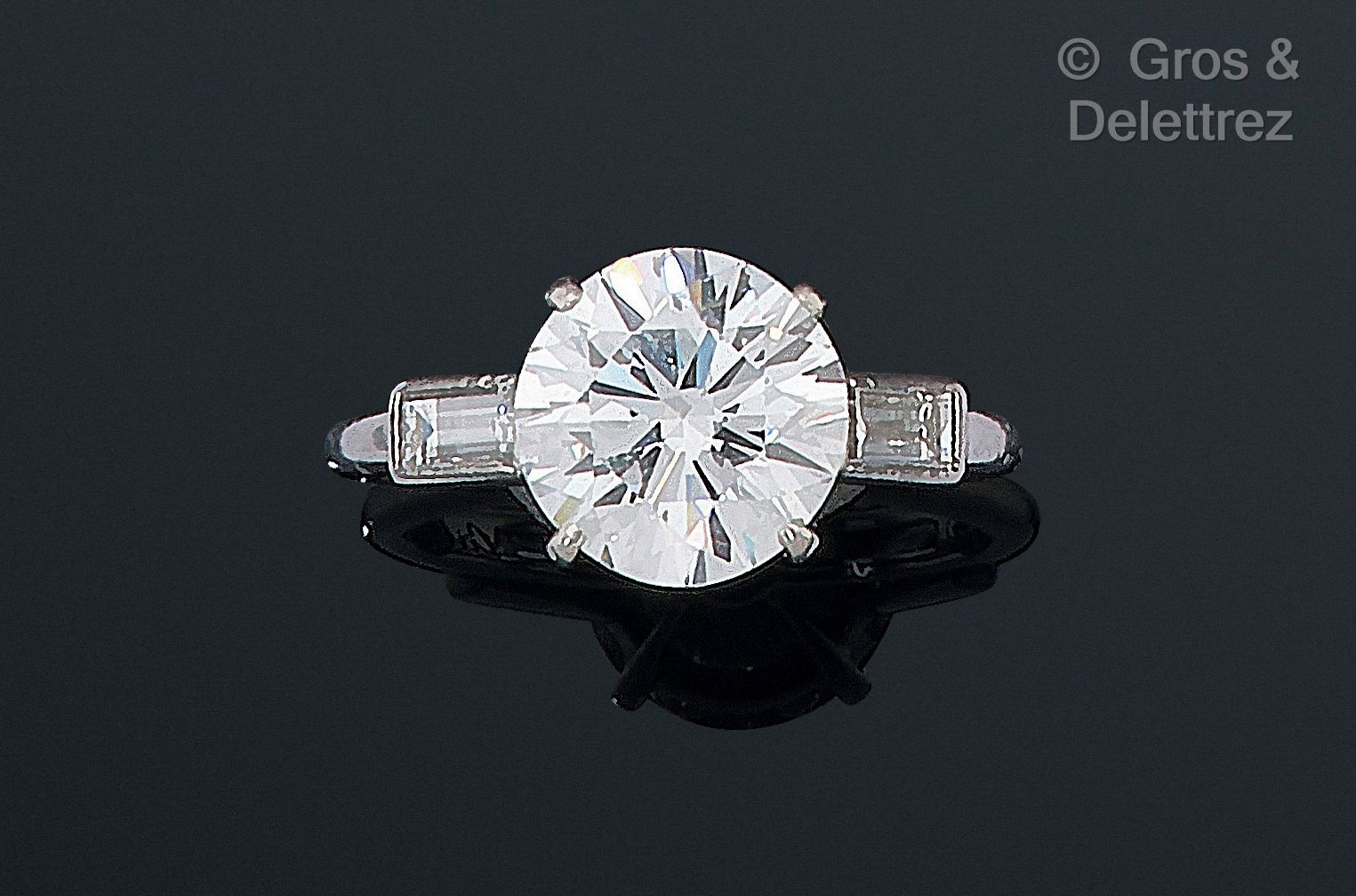 Null 卡地亚，1950年代 - 950千分之一铂金单钻戒指，以一颗明亮式切割钻石为中心，搭配两颗长方形切割钻石。签名为 "Cartier"，编号为 "096&hellip;