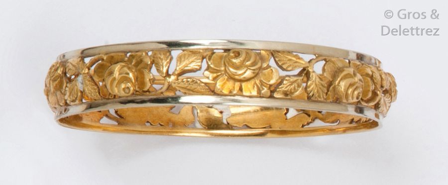 Null Bracelet rigide en or de deux couleurs ajouré à décor de roses. P. 41,5g.