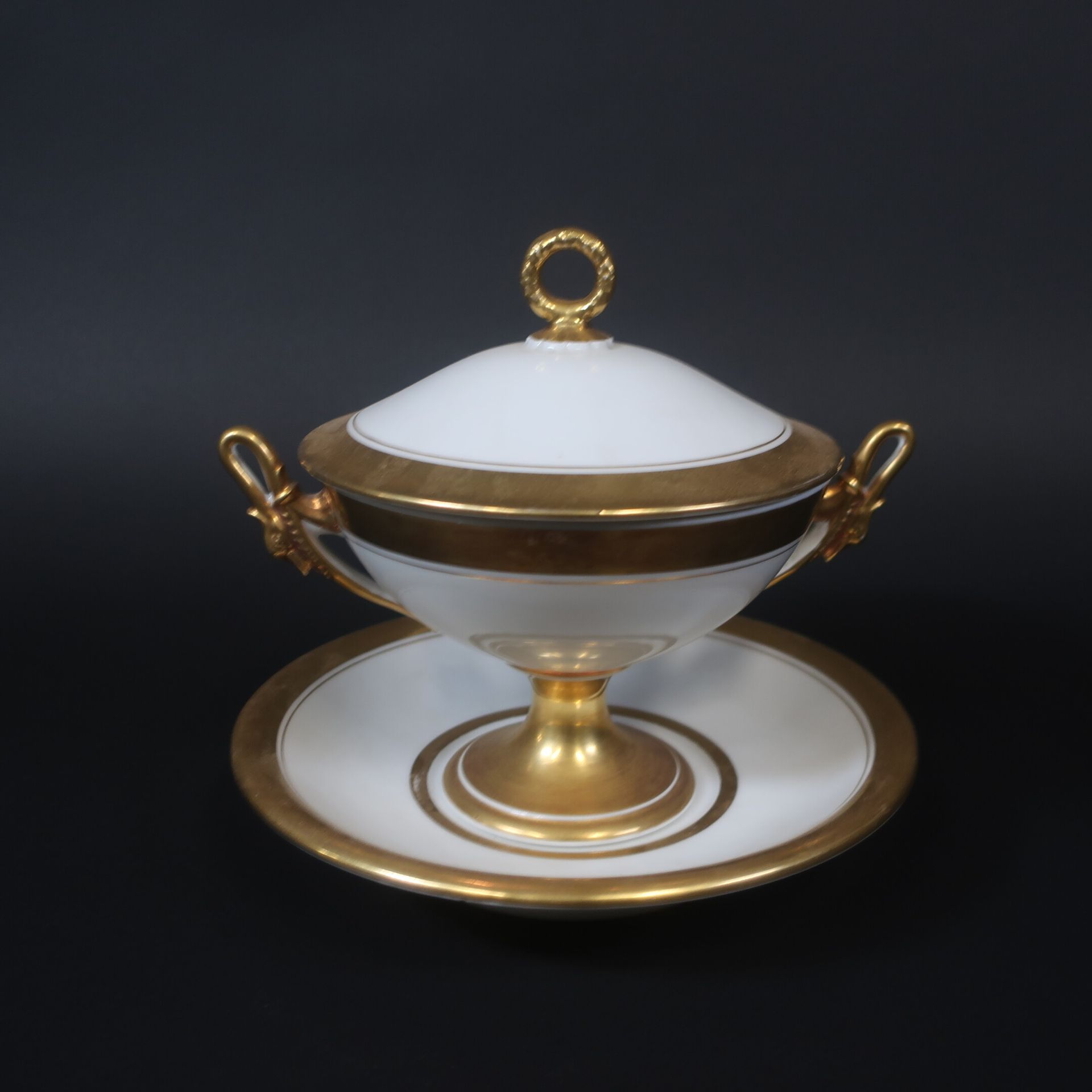 Null Bouillon couvert sur présentoir en porcelaine à réhauts dorés, anses en col&hellip;