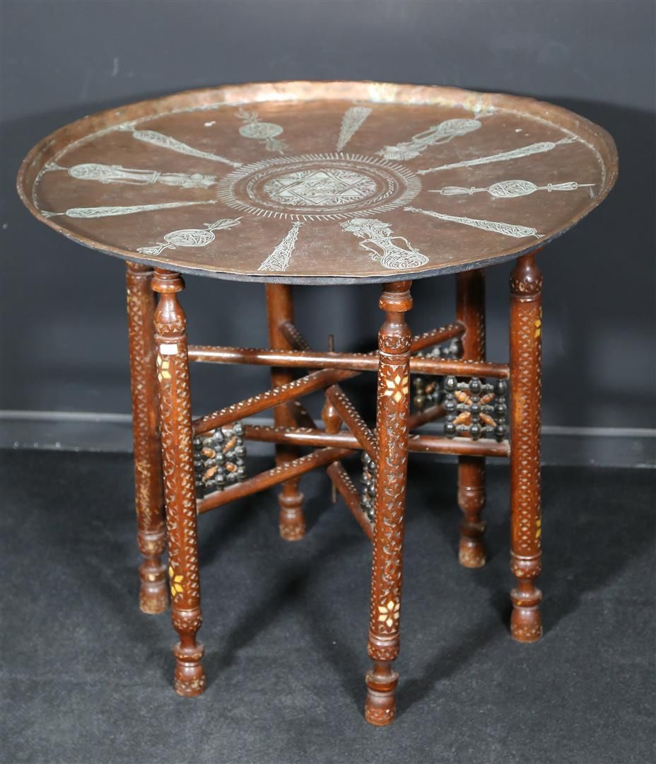 Null SYRIA - A low table with a large copper top decorated with stylized plant m&hellip;