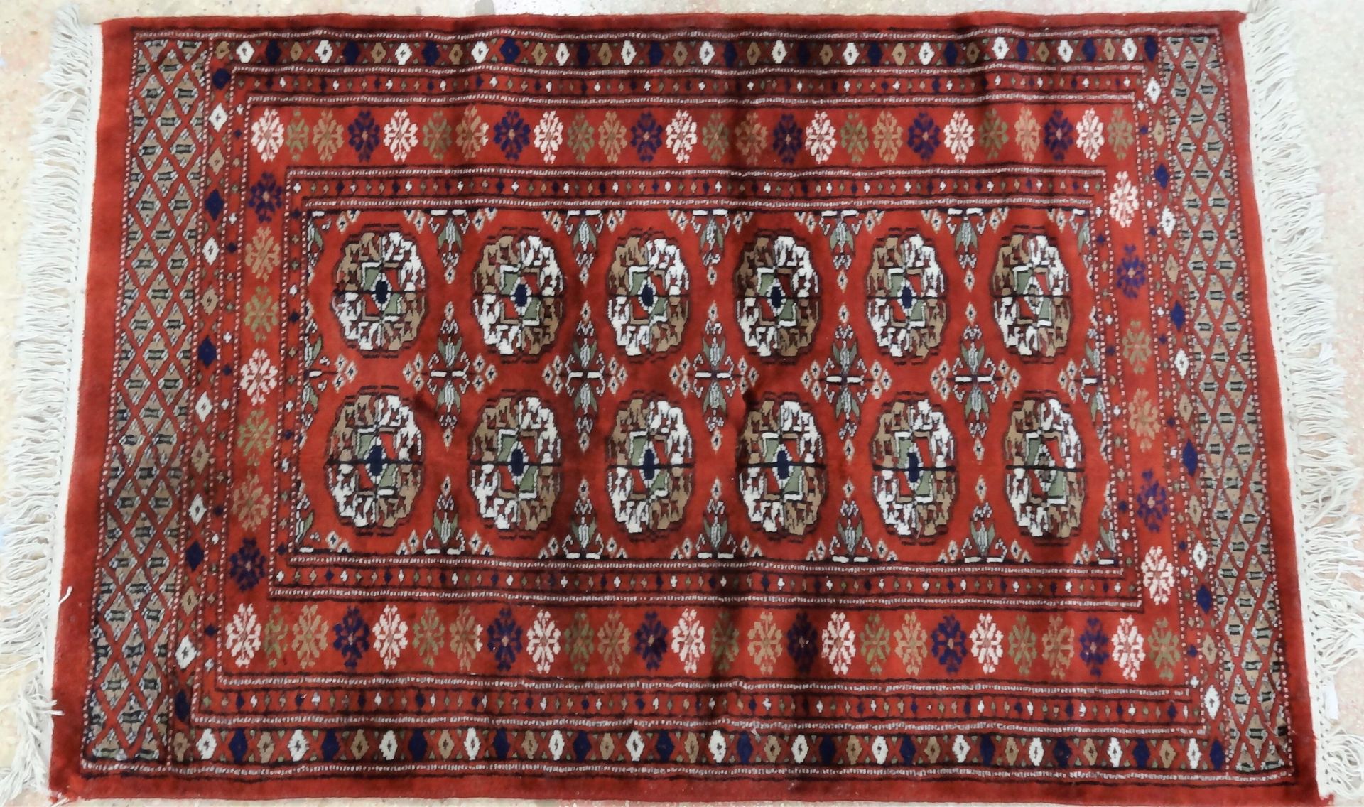 Null Tapis d'Orient en laine nouée à décor de dix güls sur fond rouge. 120 x 85 &hellip;