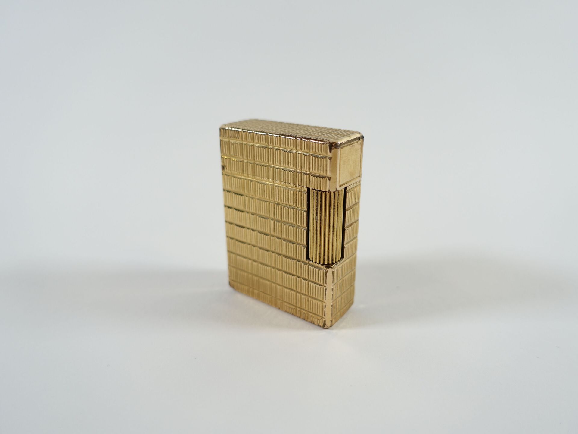 Null S.T. DUPONT: Encendedor de metal dorado con motivos estriados. 47 x 34 mm