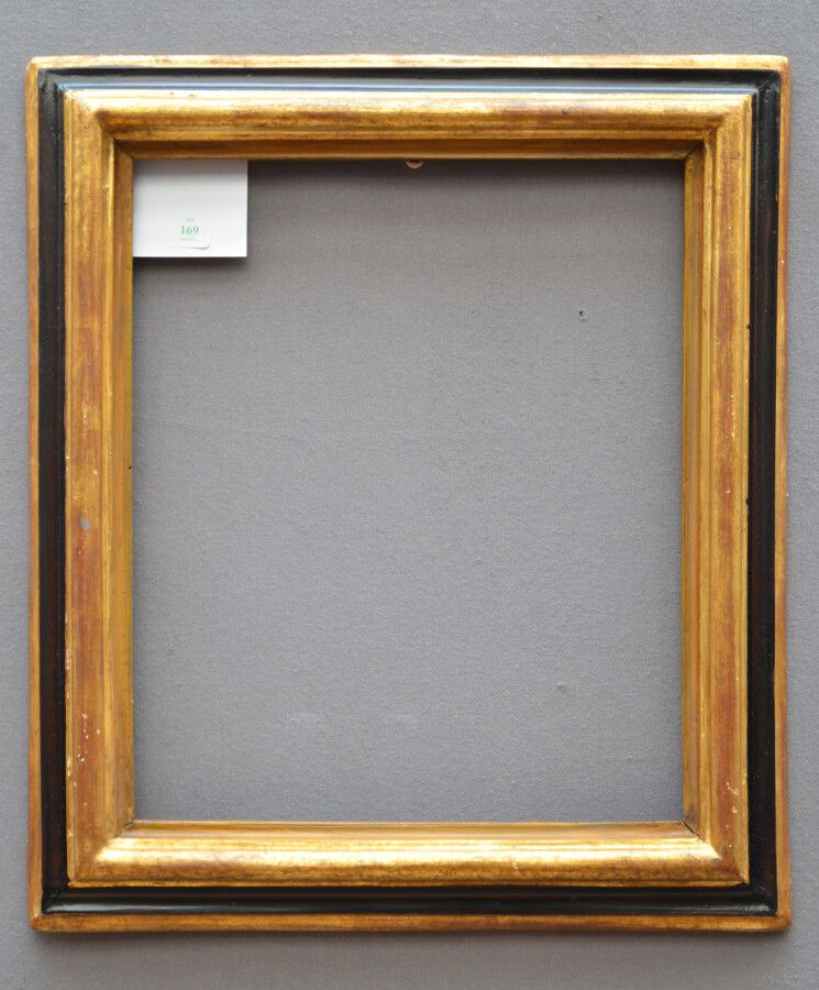 Null 一个模制的、镀金的和发黑的木质框架，有一个倒置的轮廓

意大利，18世纪

32,5 x 27 x 5,5 cm