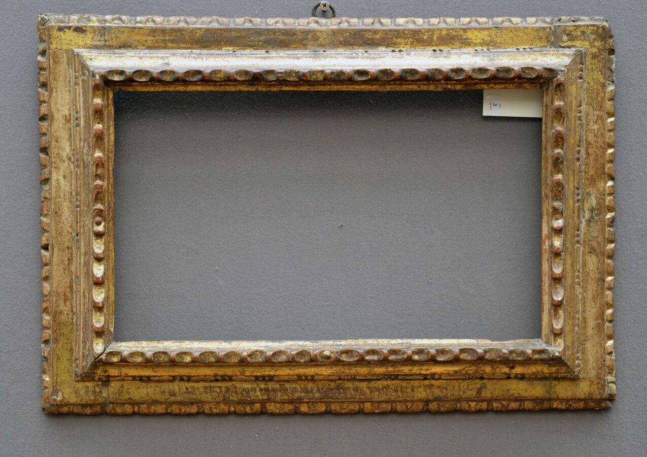 Null 一个模制、雕刻和镀金的木框，上面有桂冠和心形的门楣。

意大利，17-18世纪。

45.5 x 26.5 x 8厘米