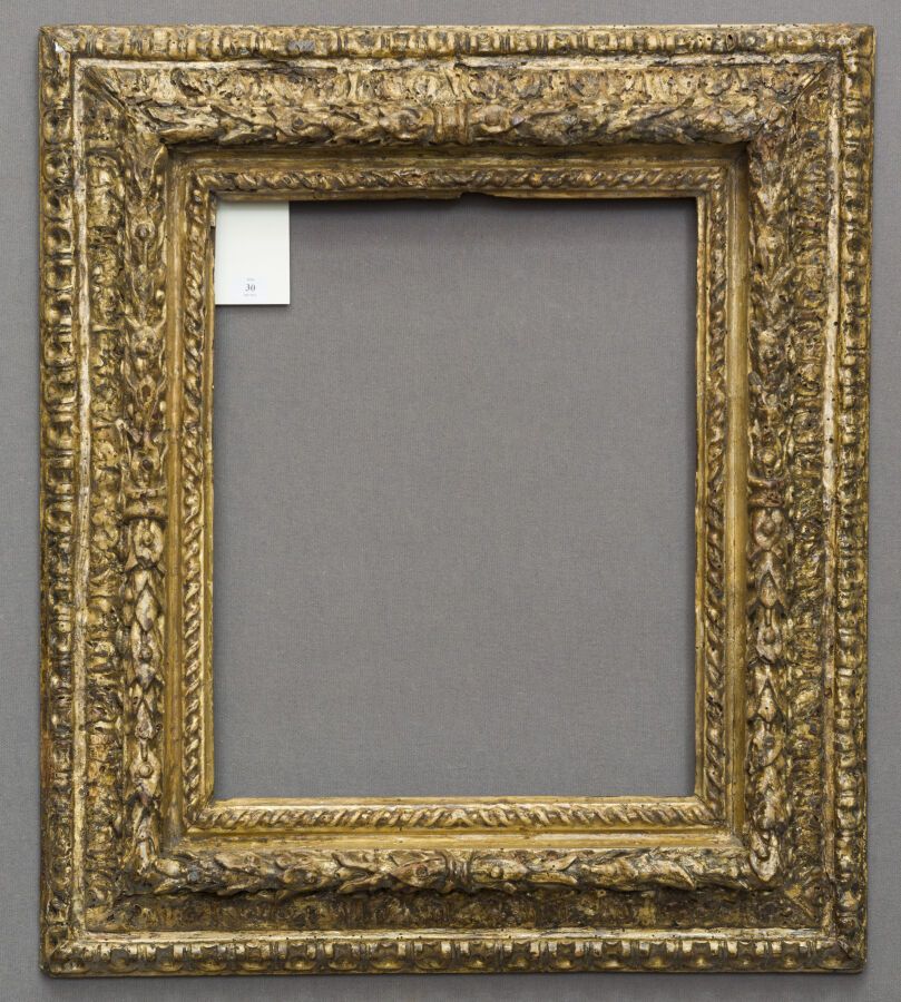 Null 一个模制的、雕刻的、以前是鎏金的木框，有锡耶纳黄的亮点。饰以扭曲的丝带、环形月桂树枝、水叶楣和橄榄枝。

意大利 17世纪。

尺寸：37.5 x 3&hellip;