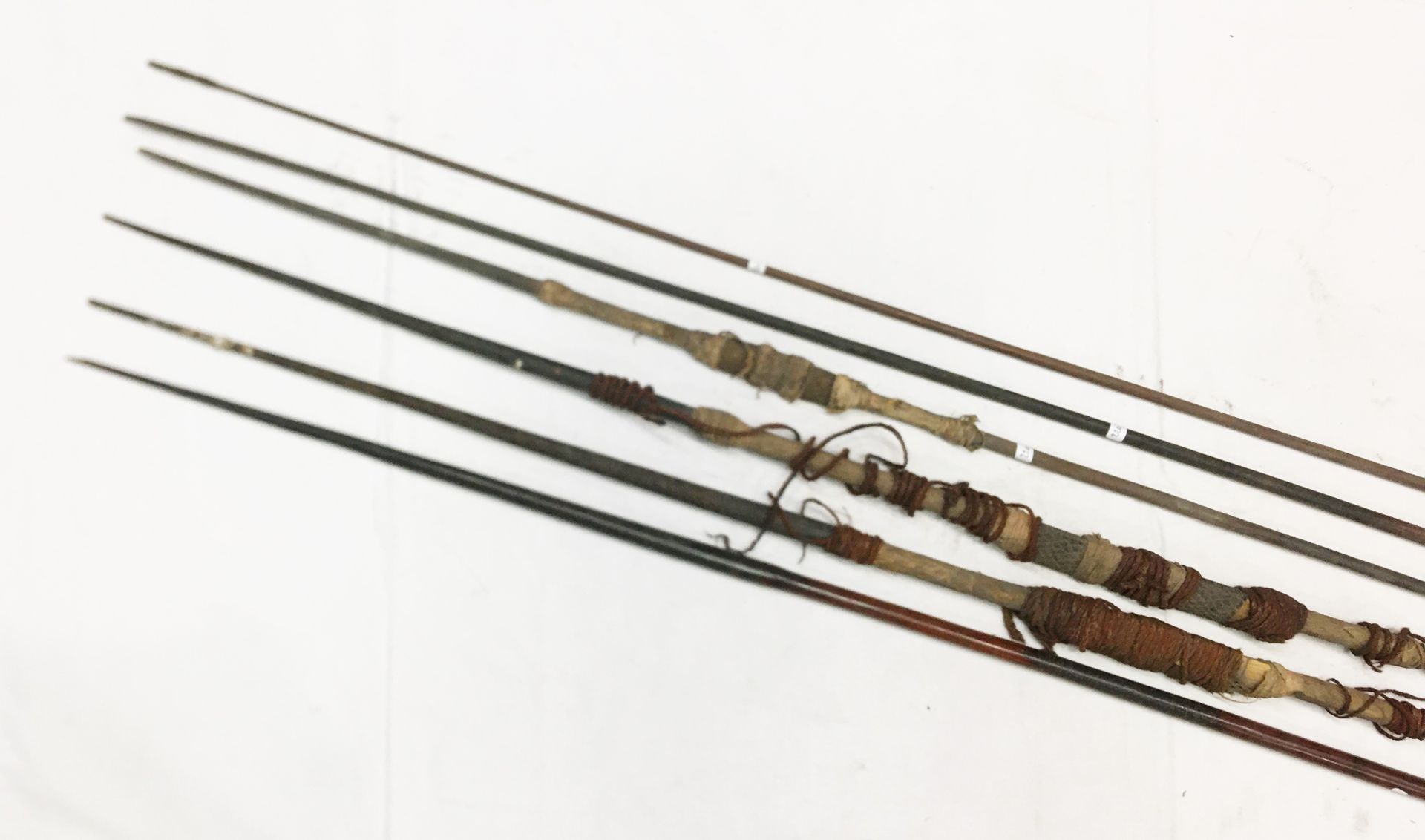 Null 一套六支Kanake硬木矛，包括三支硬币矛，中间装饰有椰子纤维、狗鱼毛和塔帕。L. : 2,55 m