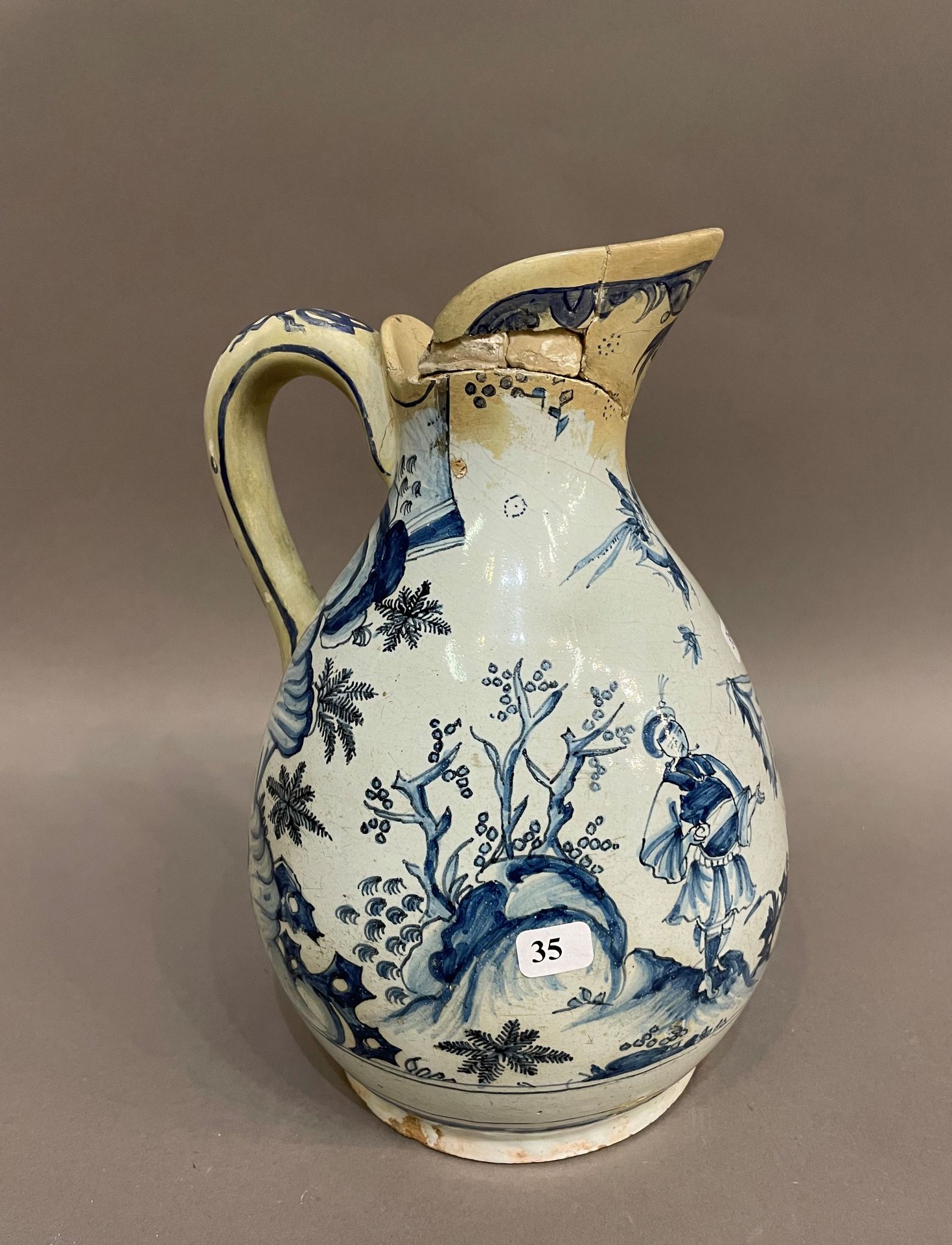 Null 里昂（？

陶罐，蓝色camaïeu装饰，有两个中国人，鸟和蝴蝶的风景。

18世纪。

H.25厘米。

颈部和手柄的事故和修复。