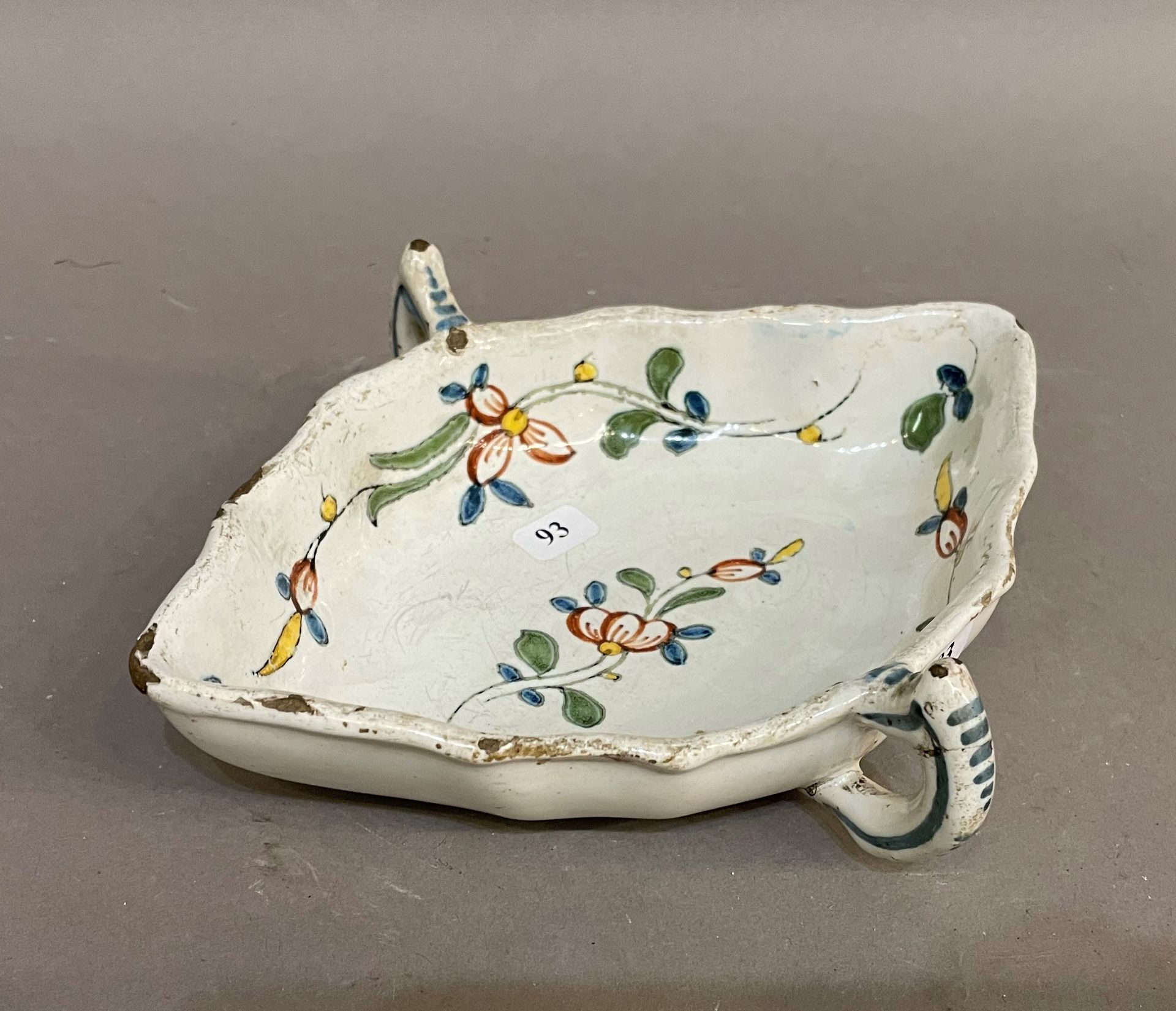 Null 鲁昂或辛切尼

椭圆形带两把的陶器酱缸，多色的花茎装饰。18世纪。

L. 20 cm.芯片。