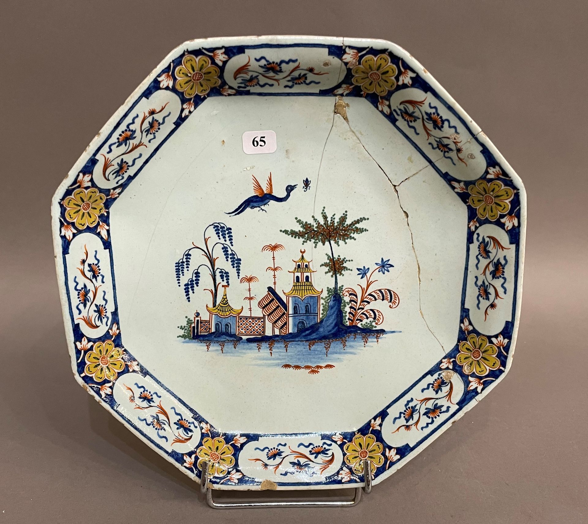 Null 鲁昂

一个八角形的陶罐，中间有多色装饰的佛塔和一只神奇的鸟，翅膀上装饰着蓝底的花纹。

18世纪。

D. 24厘米。

事故和修复