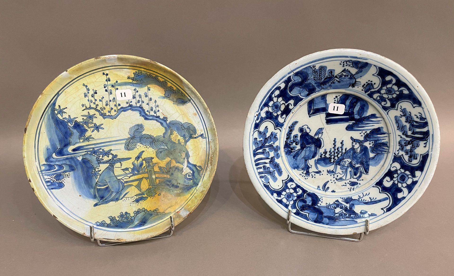 Null 内韦尔

2个圆形陶器，蓝色单色装饰的中国山水画。

17世纪。

D. 22厘米。

一个有裂纹，另一个有烧制缺陷。