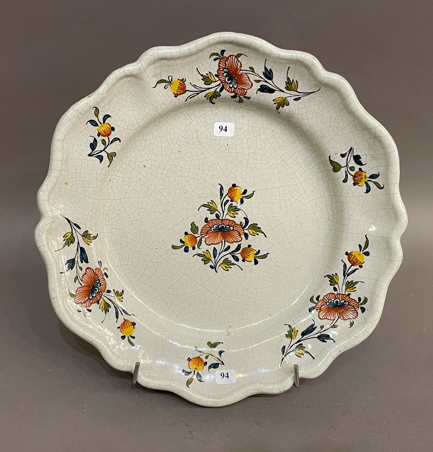 Null 辛辛那提

一个圆形的陶盘，上面有多色的花朵装饰，背面是棕色的背景。

18世纪。

D. 31厘米。