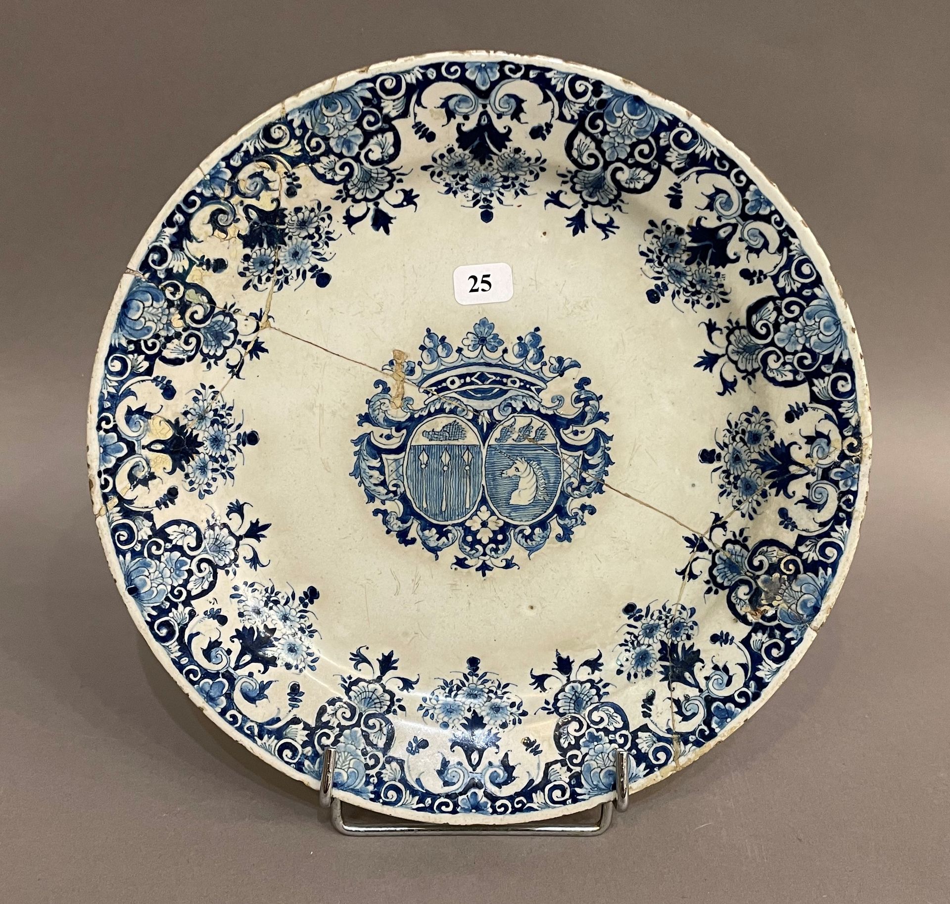 Null 鲁昂

陶器盘，蓝色单色装饰，在侯爵皇冠下的两个盾牌内有一个纹章，翼上装饰有羊脂玉和花。

波特拉的制造。18世纪初。D. 23,5 cm.

事故。