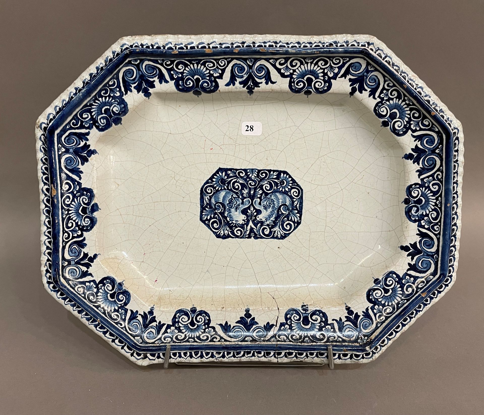 Null 法国

长方形的陶器盘子，以蓝色单色装饰的鲁昂风格，中间有两只海豚，在一个长方形的卡口中，翼上有花纹。

18世纪。

L. 35 cm.

裂开了。
