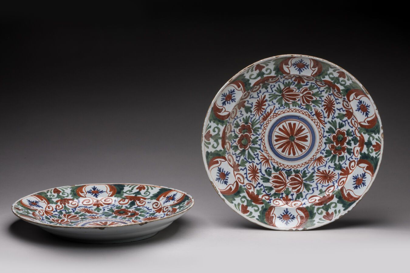 Null DELT。一对红、绿、蓝三色花卉装饰的圆形陶盘。18世纪时期。D. 33厘米。边缘上的芯片。