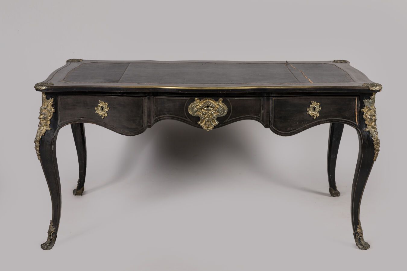 Null 一张平坦的书桌，用发黑的梨木贴面，前面有三个抽屉，靠在凸起的腿上，用镀金的青铜器装饰，如女巫、大胡子和瀑布，并有黑色的皮革顶。路易十五风格，拿破仑三世&hellip;