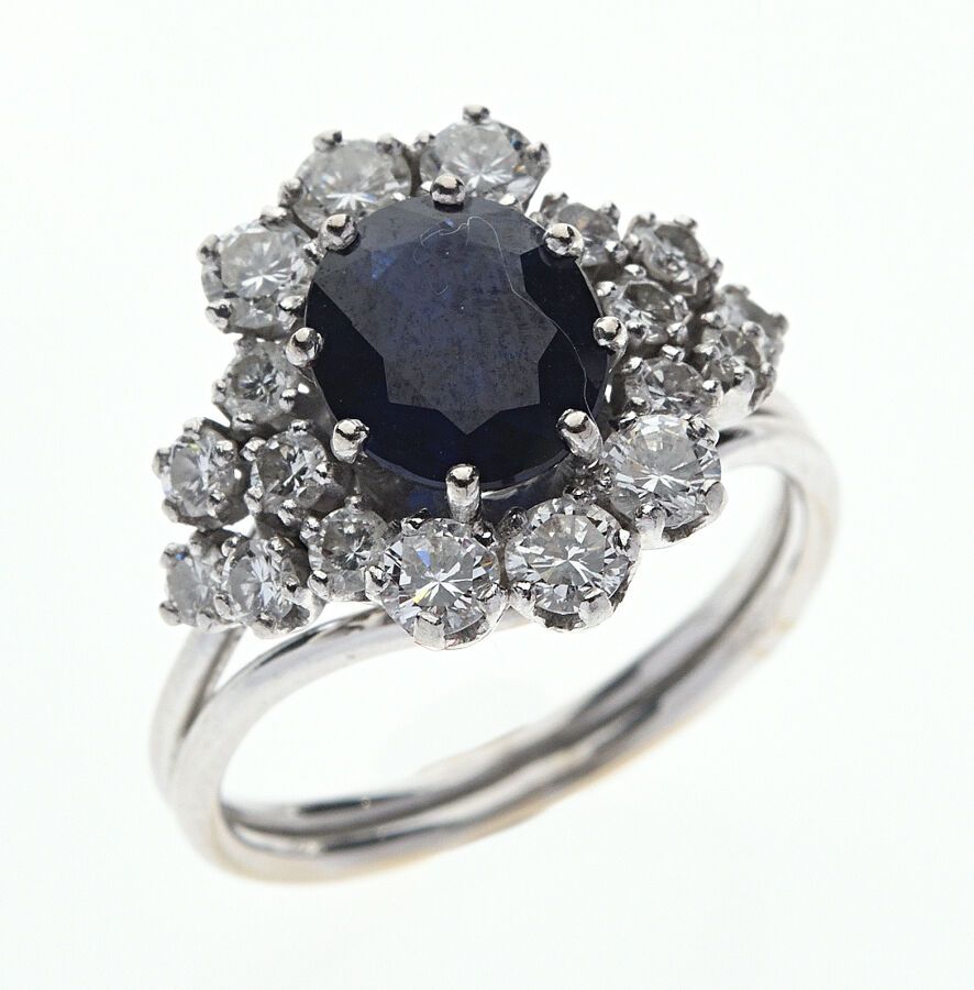 Null 750/°白金和850/°铂金戒指，在一圈下降的明亮式切割钻石中镶嵌一颗椭圆形蓝宝石。加热的蓝宝石。法国作品，HV大师标记，中间有一只手。手指大小：5&hellip;