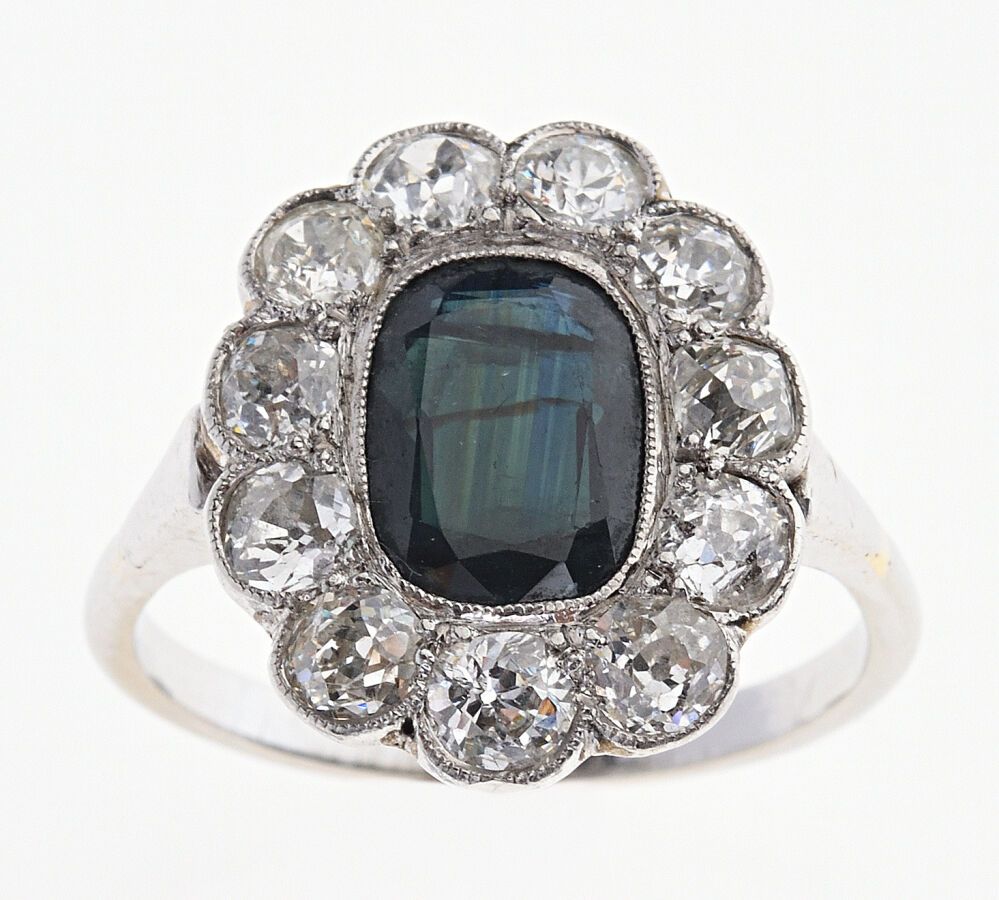 Null Marguerite "戒指，白金750/°°和铂金850/°°，镶有一颗9.3 x 7 x 3.8毫米的椭圆形枕形蓝宝石，并镶嵌有11颗老式切割钻石&hellip;