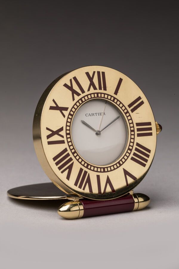 Null CARTIER - 鎏金金属旅行钟，酒红色珐琅，罗马数字，石英机芯。与其保证书和文件以及箱子一起出售，买于1992年。D. 5.2厘米。状况非常好，有&hellip;