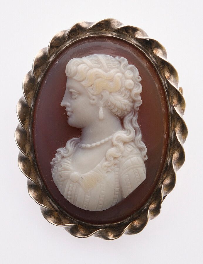 Null 棕色玛瑙上的CAMEE，装饰着一个年轻女子的侧面，面向左边，戴着珍珠项链。19世纪时期。镀银的金属框架。3.7 x 2.9厘米。