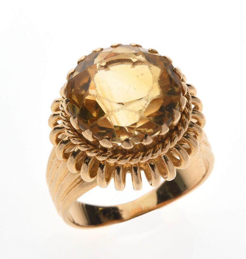 Null 镶嵌有13.5 x 9.3毫米的圆形黄水晶的镂空黄金戒指。法国作品，约1960年。手指大小：57。毛重：12.0克。石材要重新抛光（重要的划痕）。