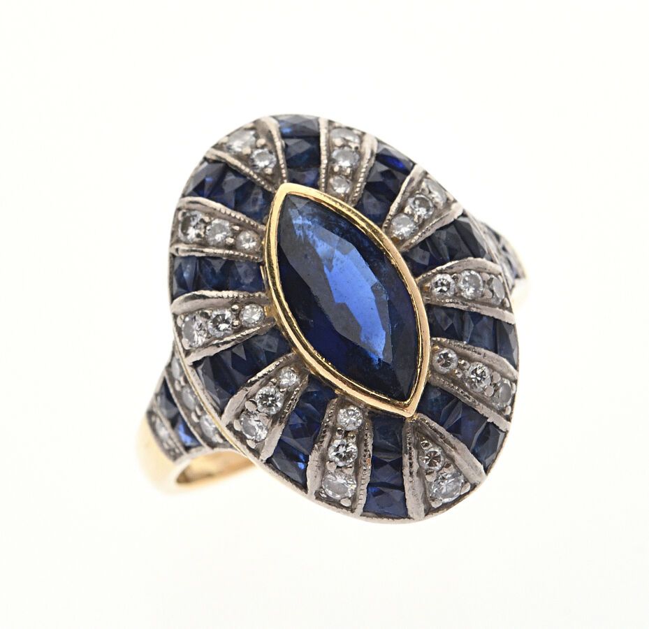 Null 750/°°黄金 "榄尖形 "戒指，镶有一颗脐带蓝宝石，周围镶嵌蓝宝石和钻石。手指尺寸：52（戒指内的镶嵌板）。毛重：5.2克。刮伤。