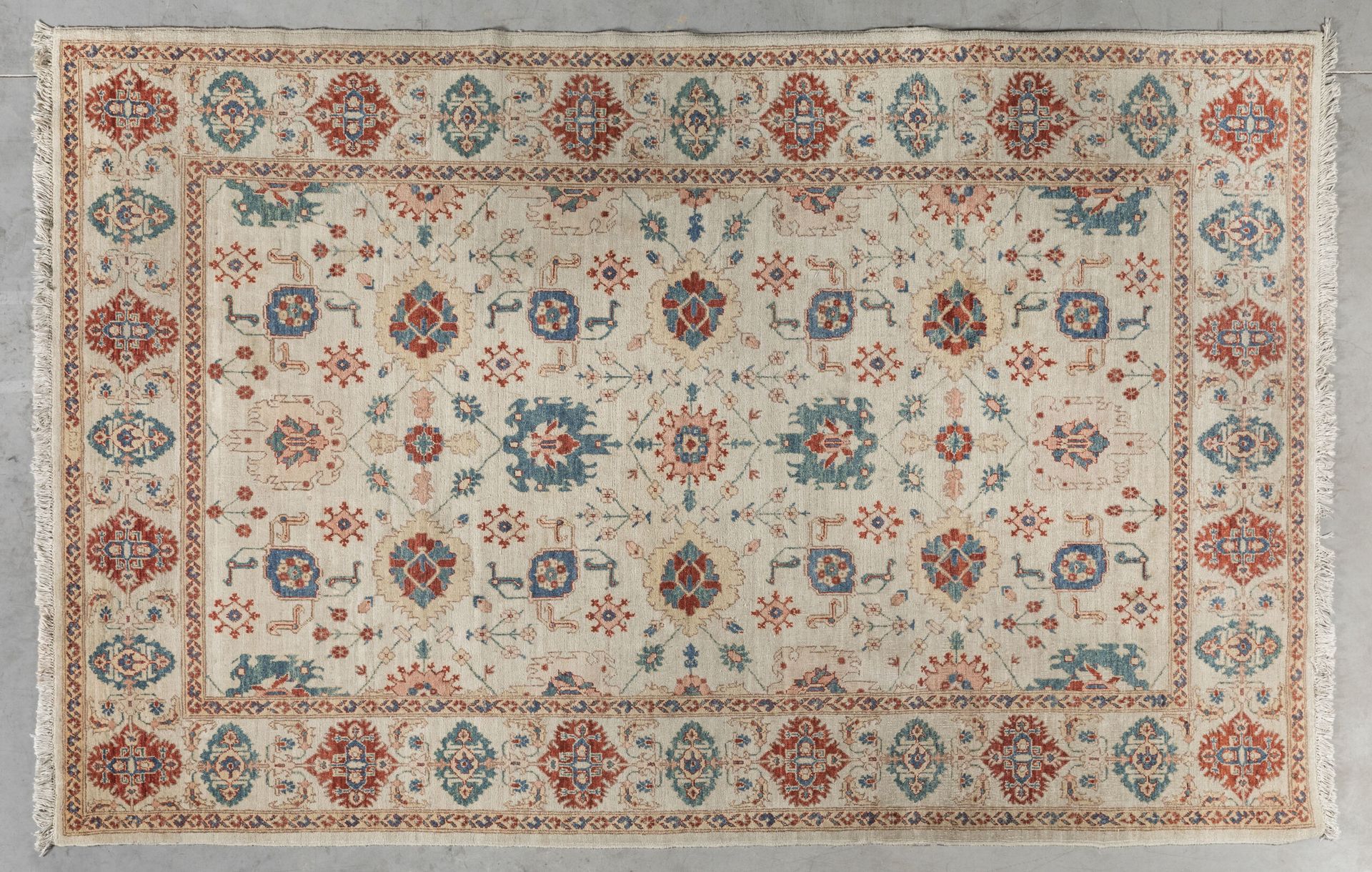 Null 巴基斯坦地毯，在浅色背景和边框上装饰着风格化的花朵。棉质经线和纬线，羊毛丝绒。20世纪晚期。280 x 187厘米。磨损和撕裂。纪念品