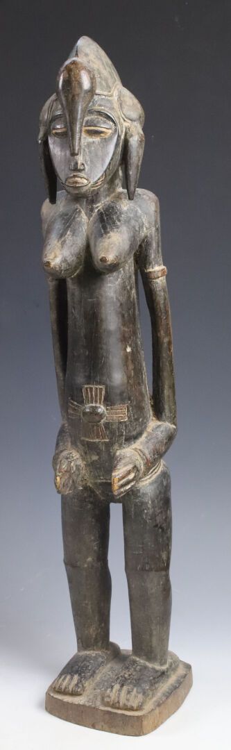 Null 雕像代表一个站在方形底座上的女性形象，装饰有手镯的手臂与身体分离，双手放在大腿上部。肚脐周围有疤痕。面部呈心形，下巴向前突出。发型是一个月牙形的徽章，&hellip;