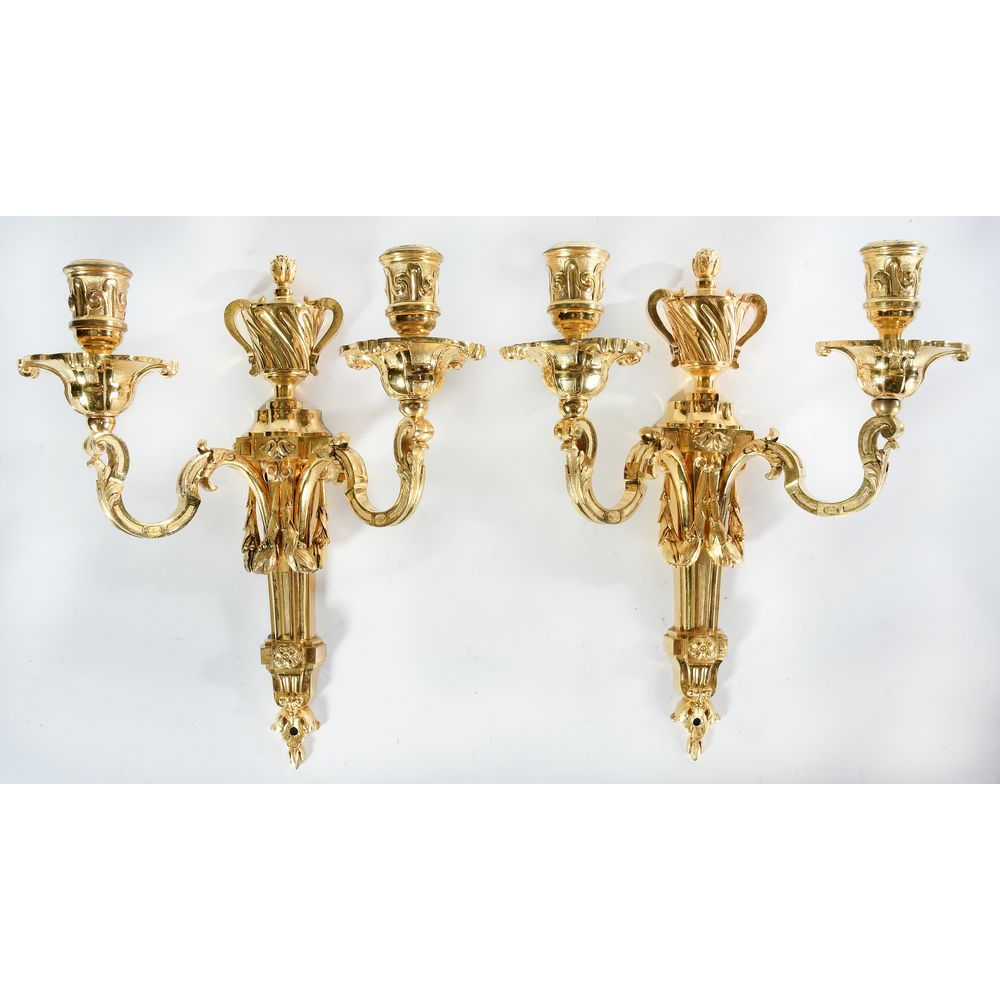 Null 一对鎏金铜制的过渡壁灯，有2个灯。它们带有月桂花环、药瓶和树叶的图案。18世纪。H.31 L.25.