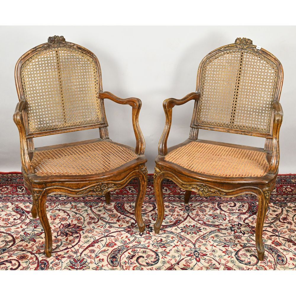 Null 一对路易十五时期的扶手椅，天然木制，有模子。座椅和椅背为藤条。椅腿和扶手为鞭状。雕刻着小花的图案。十八世纪。长57英尺，高94英尺。