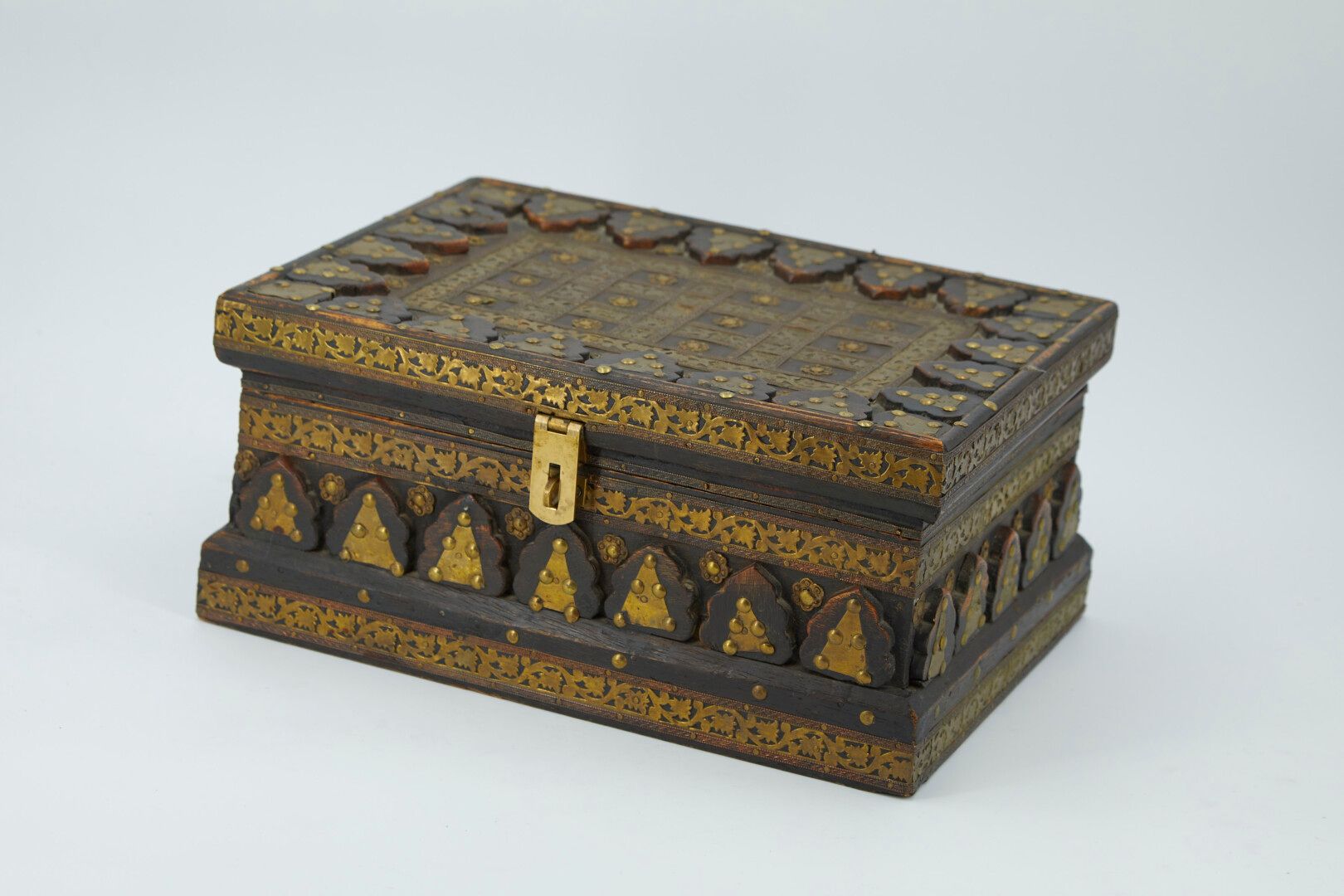 Null 长方形的木箱结构，边框上有黄铜装饰的三角形，盖子上有花的楣子，形成网格。

摩洛哥人的作品 第20届。

14.5x30.5x23厘米