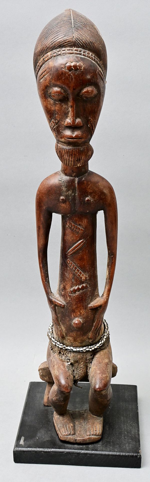 Null Ancestor figure Ivory Coast, Baule wood, carved. Male figure sitting on sto&hellip;