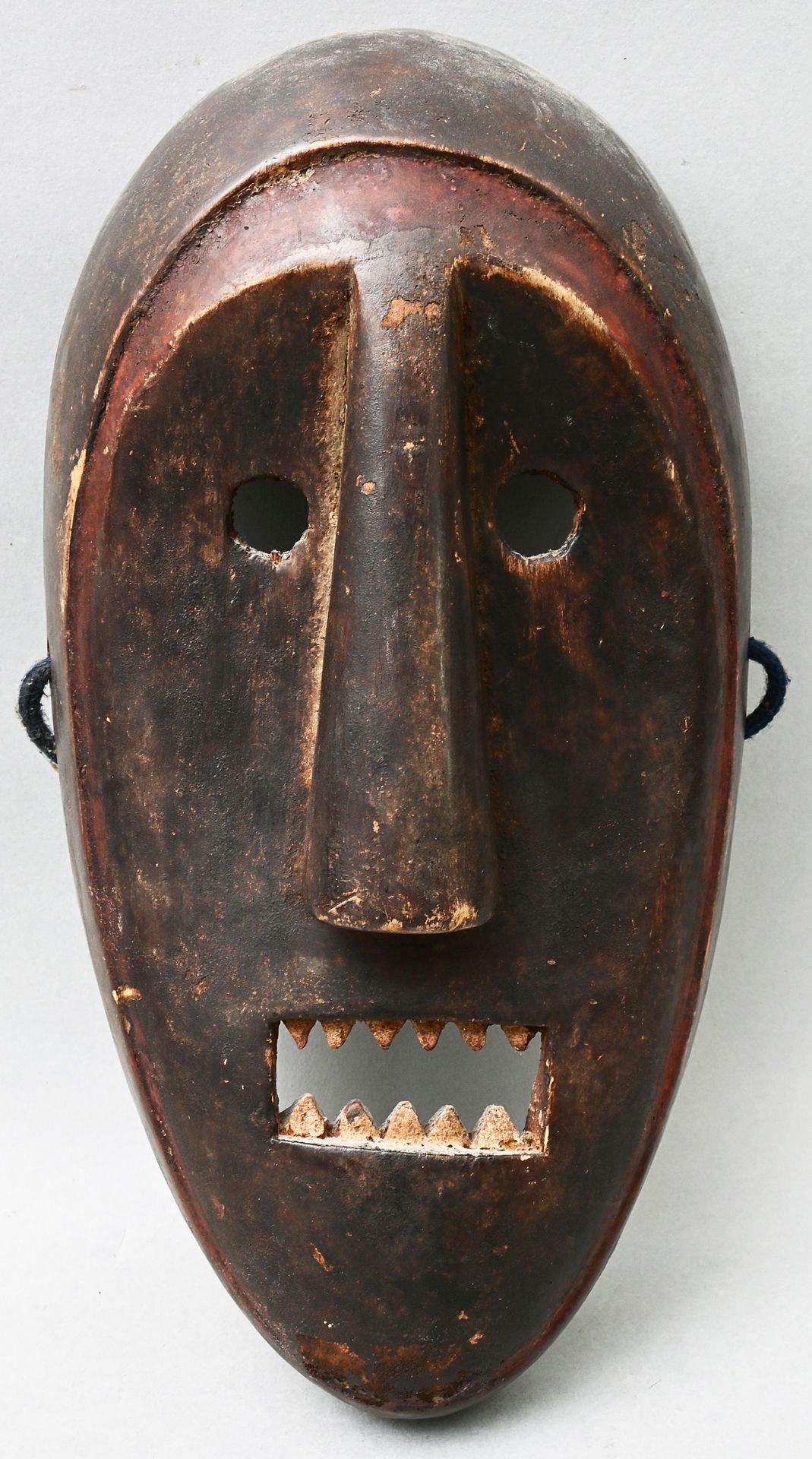 Null 面具，印度尼西亚（？）拟人化的脸部面具，木头，雕刻，深棕色的铜锈，边缘用红色颜料衬托。白色颜料中的一排排牙齿。高32.5厘米 出处：私人财产，符腾堡州&hellip;