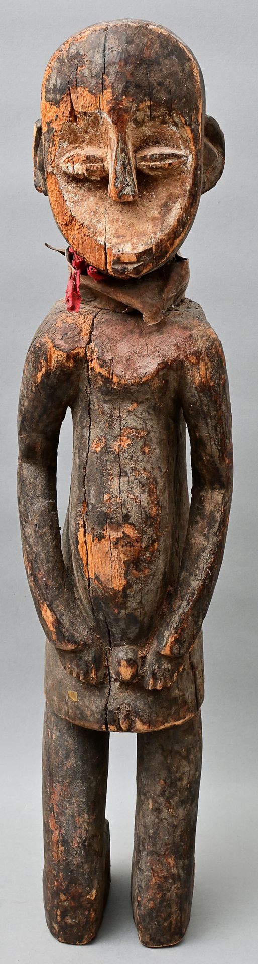 Null 图 Rega (Lega), D. R. 刚果 男性跪姿，木头，雕刻，深色铜锈，脸上有白色颜料的痕迹。脖子上有动物皮条和红色棉布。裂缝，风化损坏。高6&hellip;