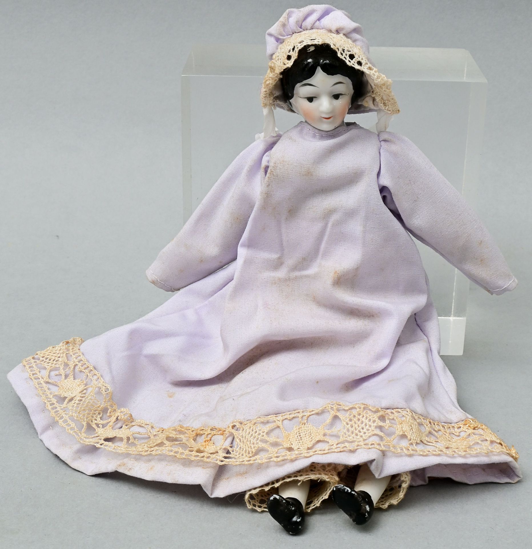 Null 小瓷娃娃，20世纪70年代的瓷质胸叶头，面部和头发都有彩绘。布质身体，手和脚（双色瓷）。浅紫色连衣裙，带长裤和内衣。衣服弄脏了。高20厘米 小瓷娃娃 &hellip;