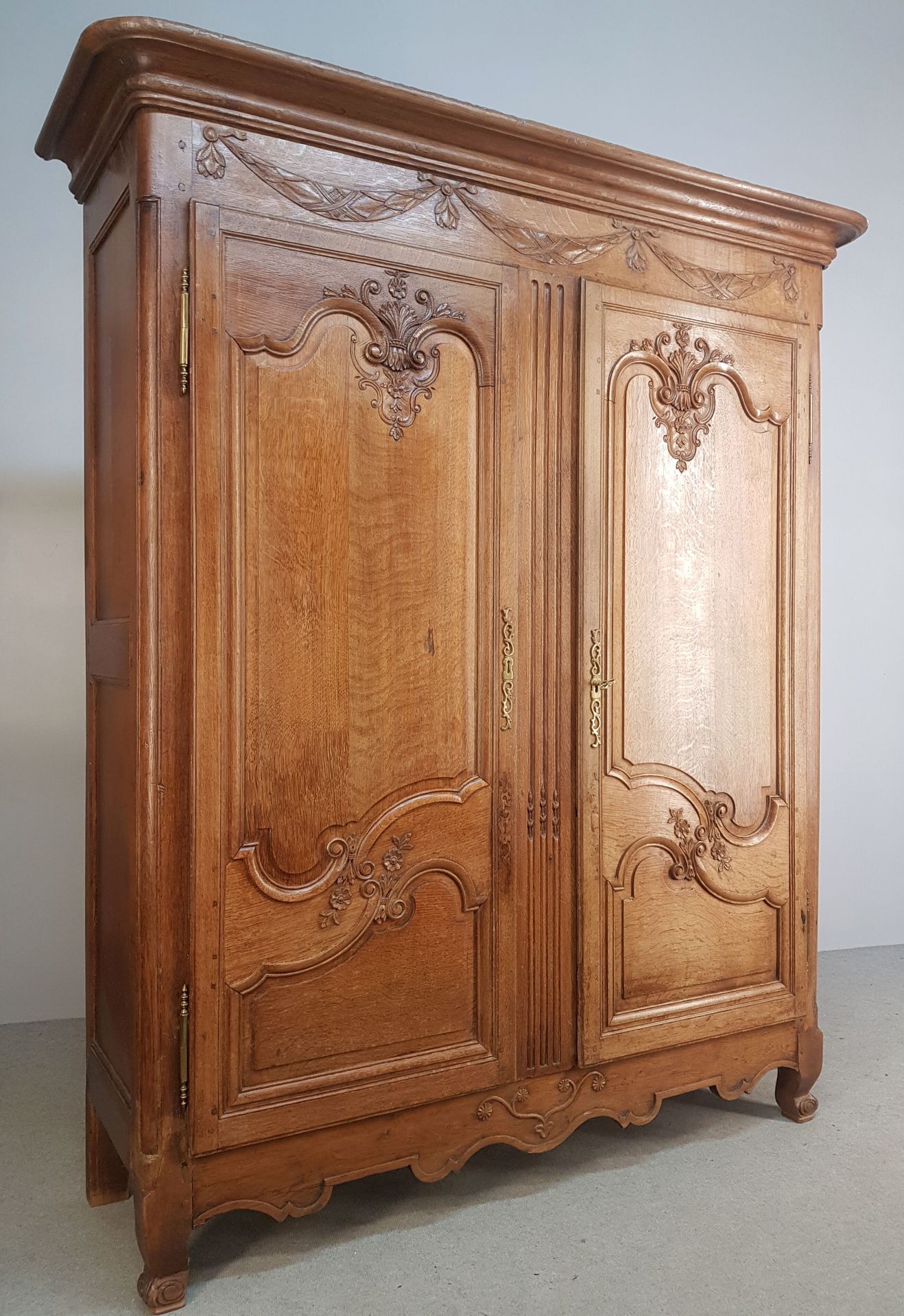 Null ARMOIRE en chêne ouvrant par deux portes moulurées et sculptées de fleurs, &hellip;