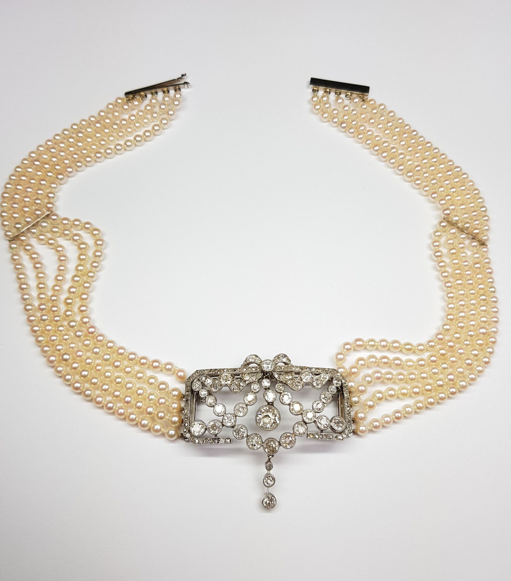 Null 一条五排养殖珍珠项链，长3-3.5厘米，以长方形的950‰铂金盘为中心，在585‰白金上镶嵌花环，顶部有一个蝴蝶结，全部镶嵌钻石，包括老式切割和玫瑰式&hellip;