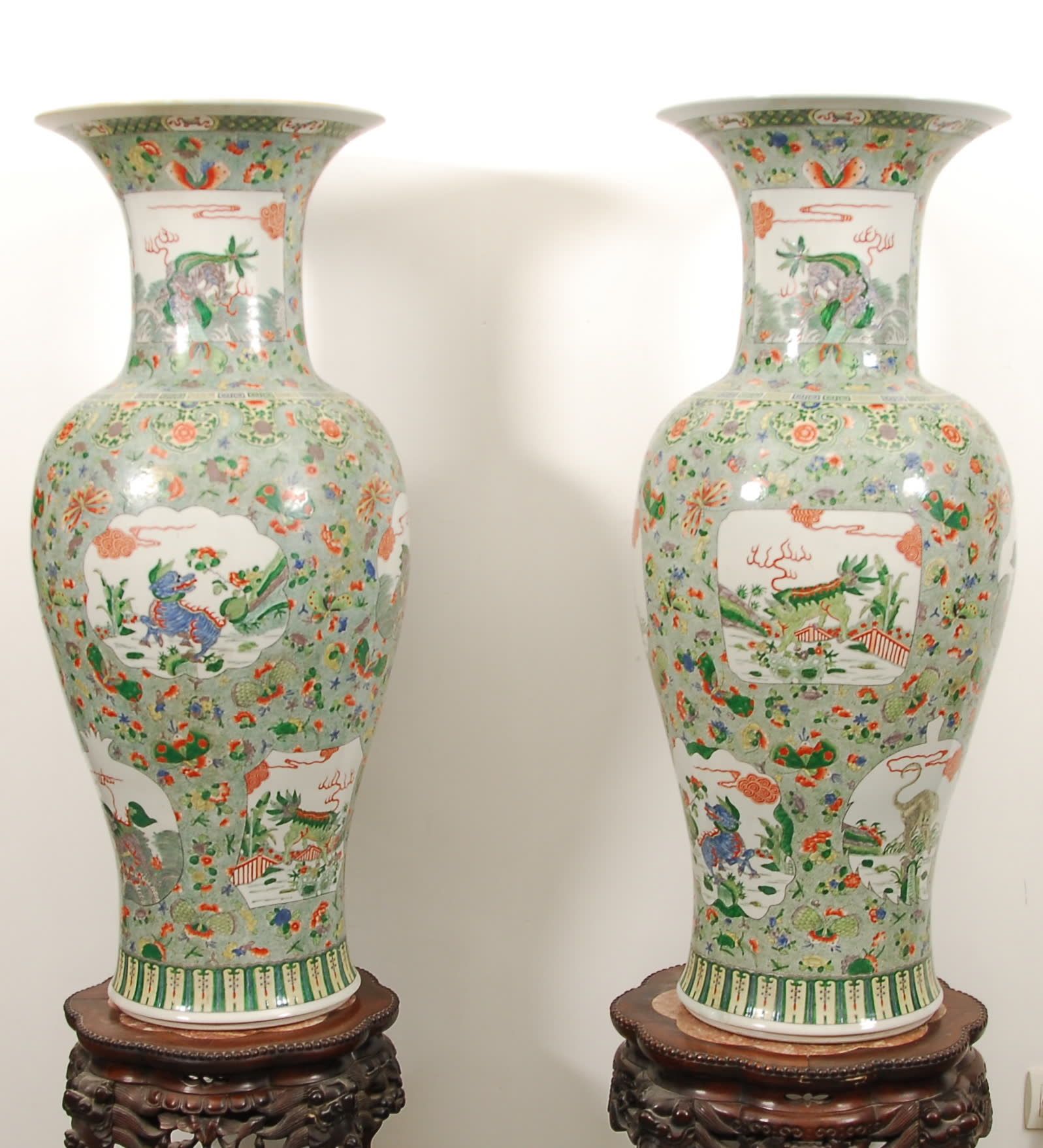 Null 一对大柱形花瓶
绿色家族珐琅彩的多色装饰，在以蝴蝶和花朵装饰的背景上有神奇的动物储备。中国，清（旧时修复裂缝）。
，高104厘米。