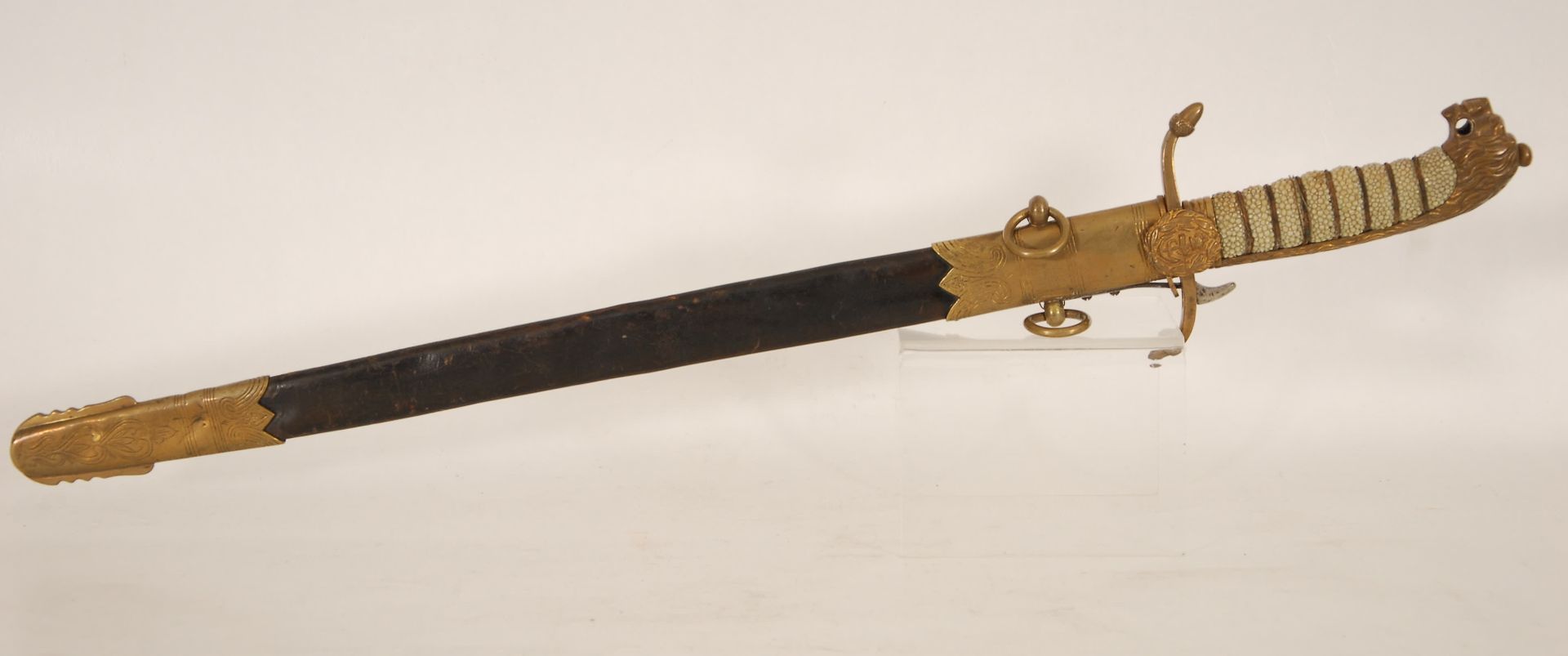 Null 海军军官的匕首
雕刻的单刃刀。狮头鞍座和花纹手柄。青铜、铜和皮革衬里的刀鞘。19世纪。
，长60厘米。