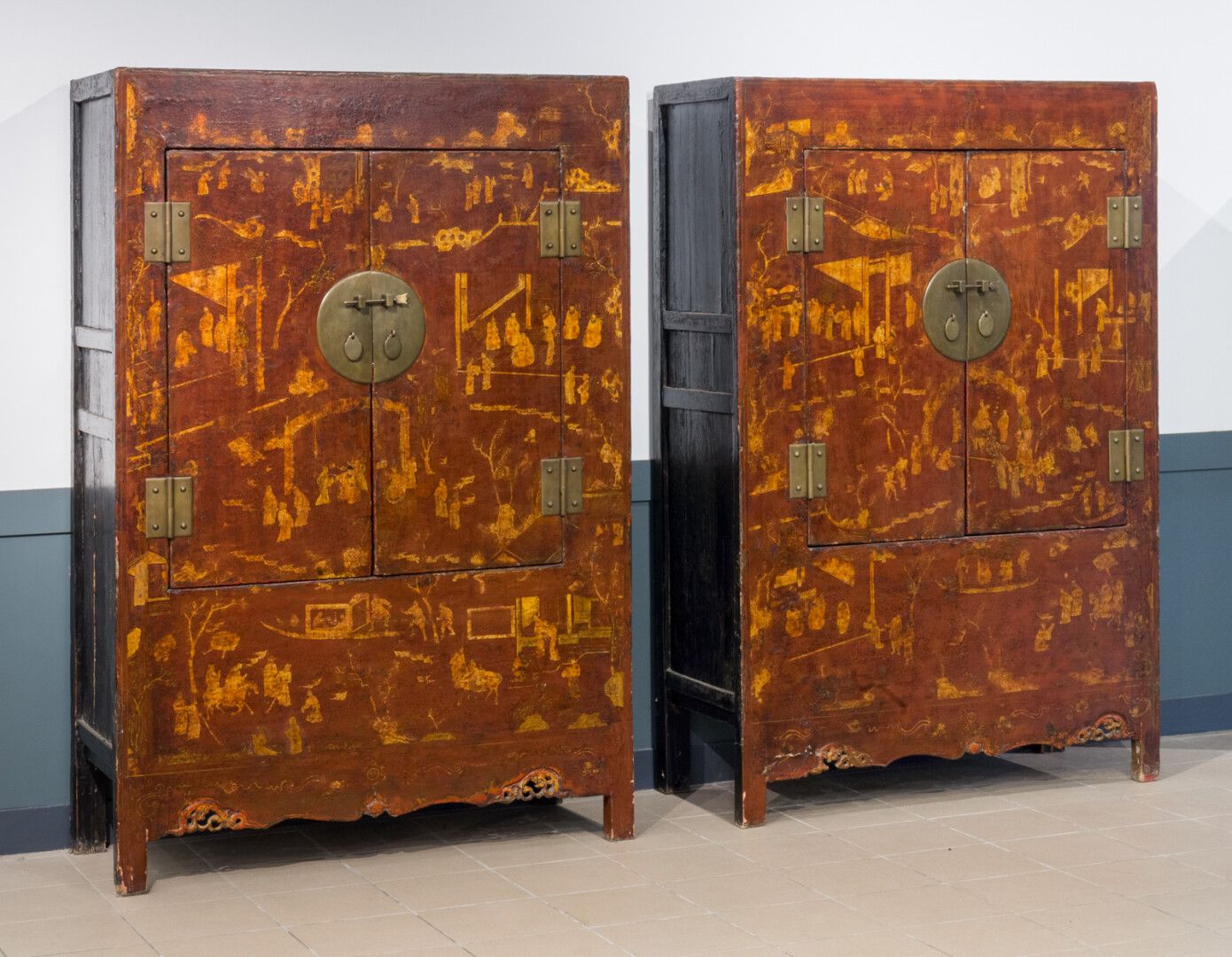 Null 一对红色和金色漆面的双门木柜，装饰着梯田树上的人物组合。

中国，20世纪

高：191 - 宽：129 - 深：51厘米（小事故和缺失的部分