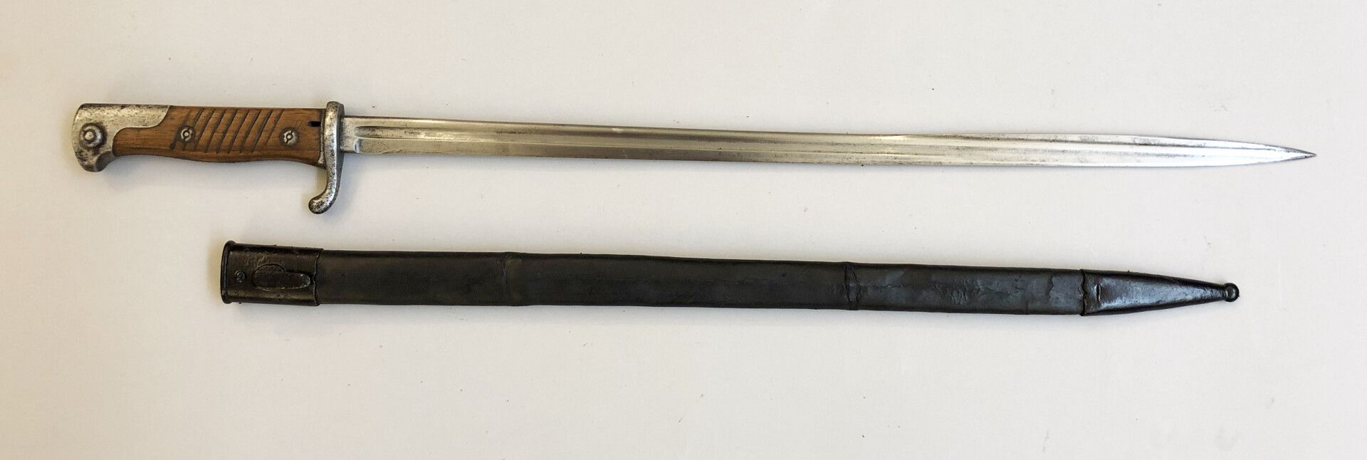 Null 德国刺刀1898年第二版。邮轮上的团徽部分被抹去（158号）。刀背上有1907年的普鲁士收据。在其皮革刀鞘中（有裂缝），有两个涂成黑色的钢制饰物。