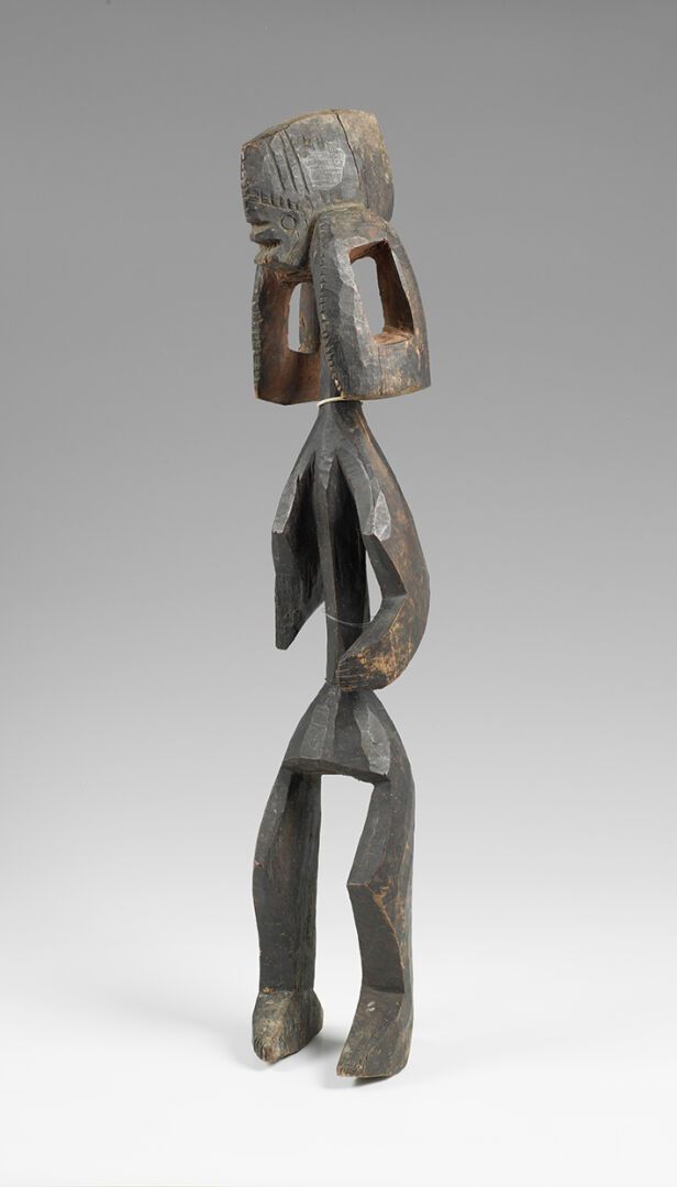Null IAGALAGANA "AUTEL雕像，硬木材质，有深色的铜锈，显示了一个雕刻着高度风格化线条的站立人物。头部扁平，面部特征简约，耳朵下垂，镂空，长腿&hellip;