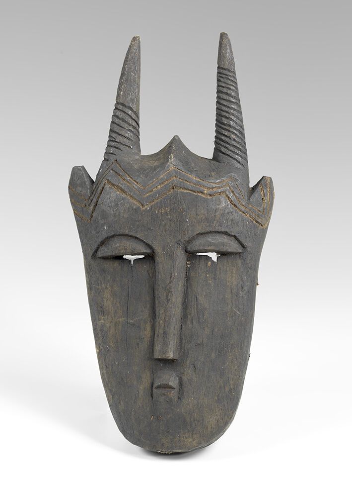Null 木制面具，有黑色铜锈，有一张人脸，上面有两个犄角。象牙海岸，BAOULE。高度：37厘米。