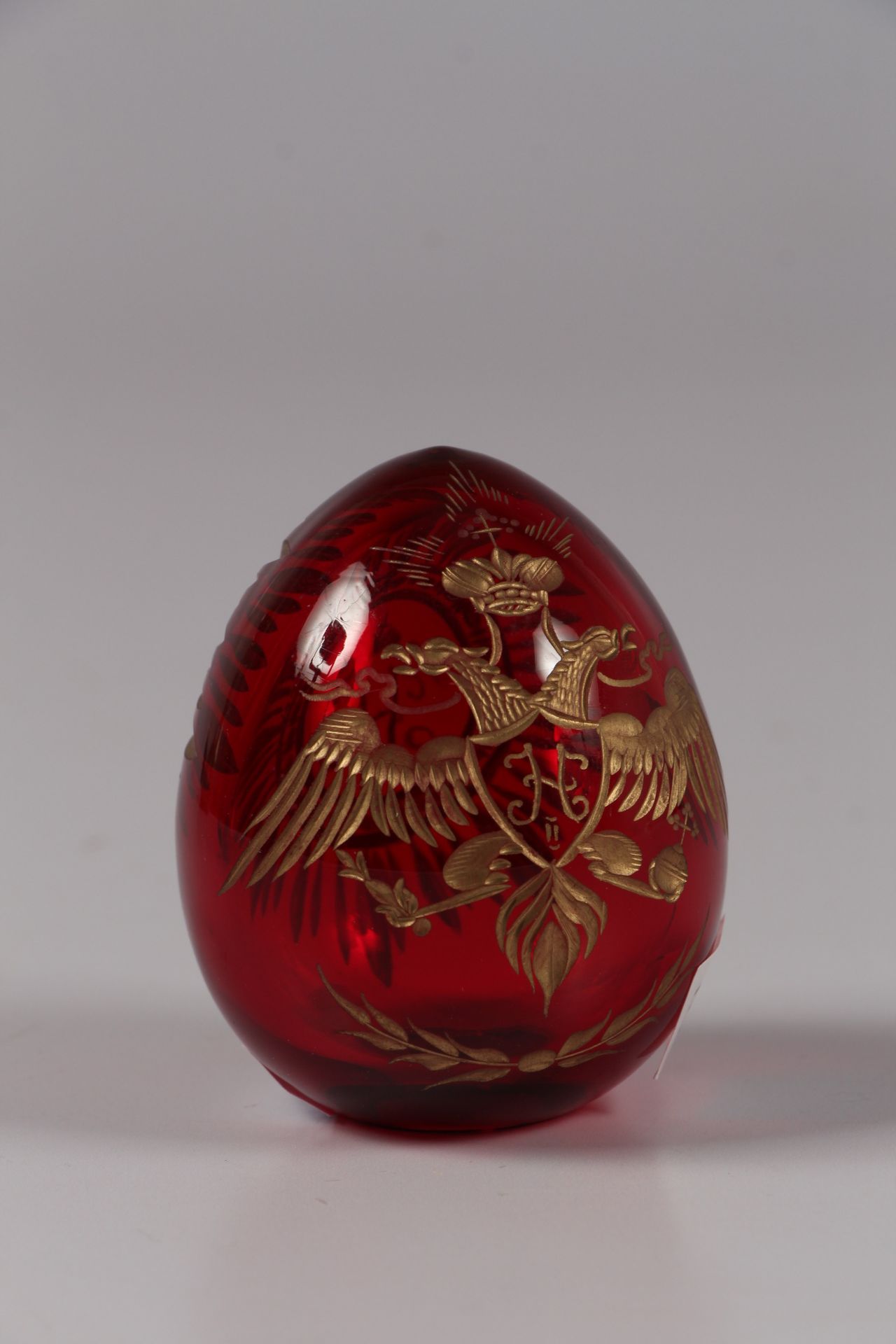 Null FABERGE.红色有色玻璃蛋，刻有双头鹰的金色装饰。

在一个基座上，高6厘米。

最近的工作