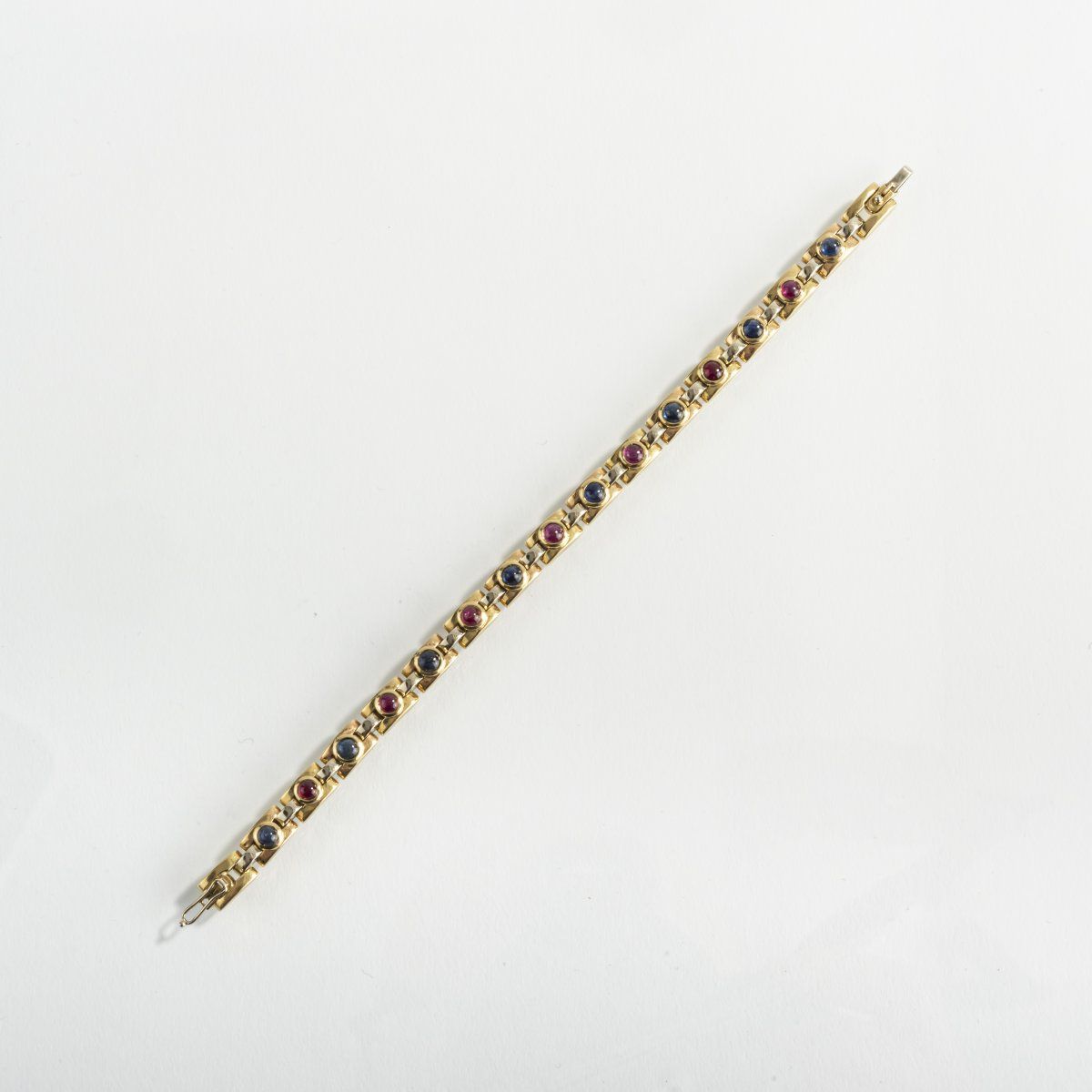 Null Italie, Bracelet, 1970, or jaune 18ct., saphirs, rubis. 39 grammes. L. (ouv&hellip;