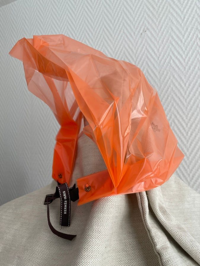 Null HERMES Paris

Rain hood in transparent orange plastic, signed, and brown bo&hellip;