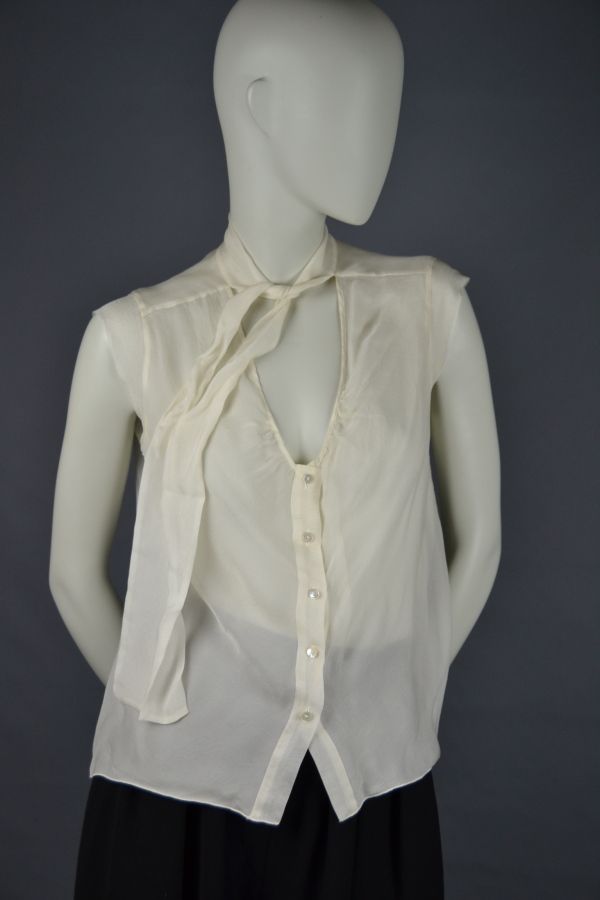 Null CHANEL

Ärmellose Bluse aus beigem Seidenchiffon, Krawattenkragen, Perlmutt&hellip;