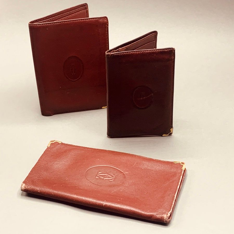 Null CARTIER

Burgundy leather wallet, two card holders and a glasses case (worn&hellip;