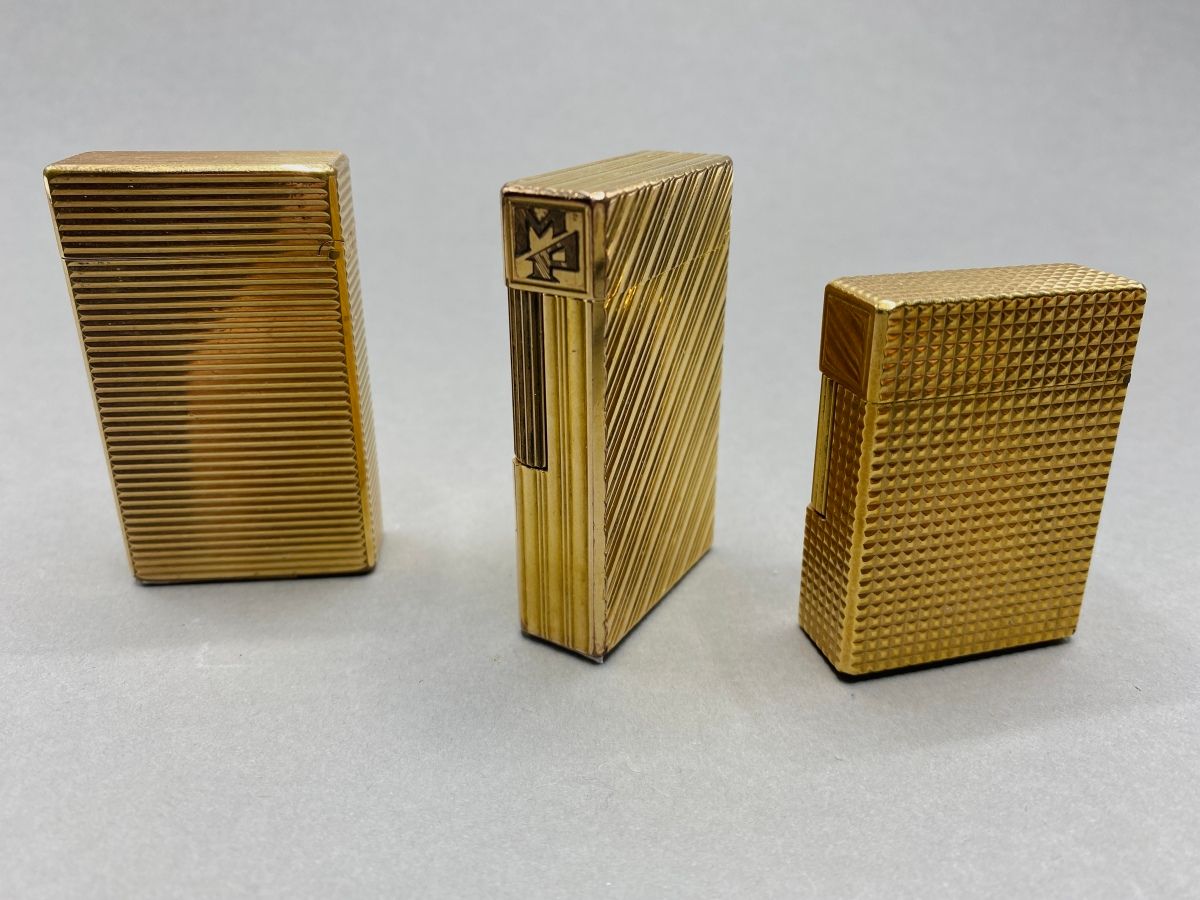 Null DUPONT

Drei Feuerzeuge aus vergoldetem Metall, eines mit eingravierten Ini&hellip;